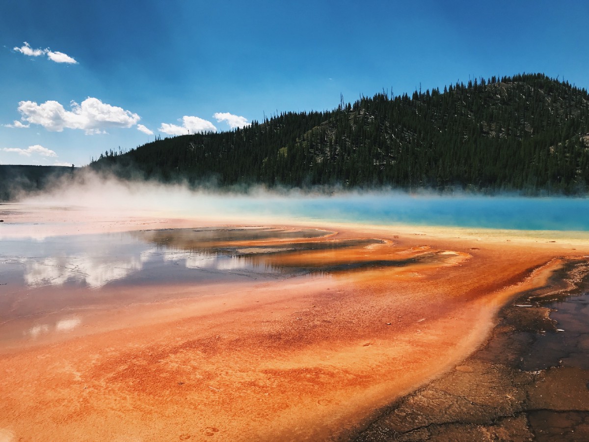 bright orange and blue body of water with steam rising off of it