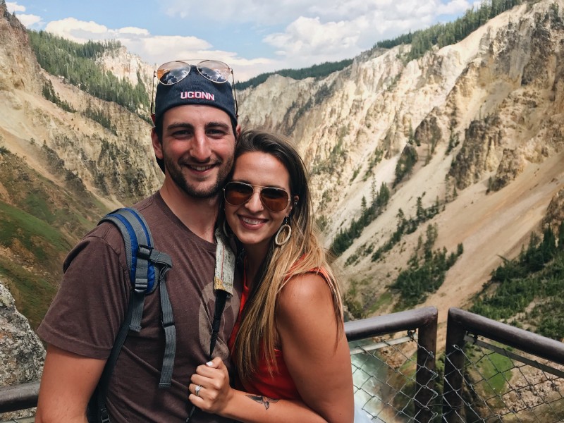 a couple standing at an overlook of a canyon with water below