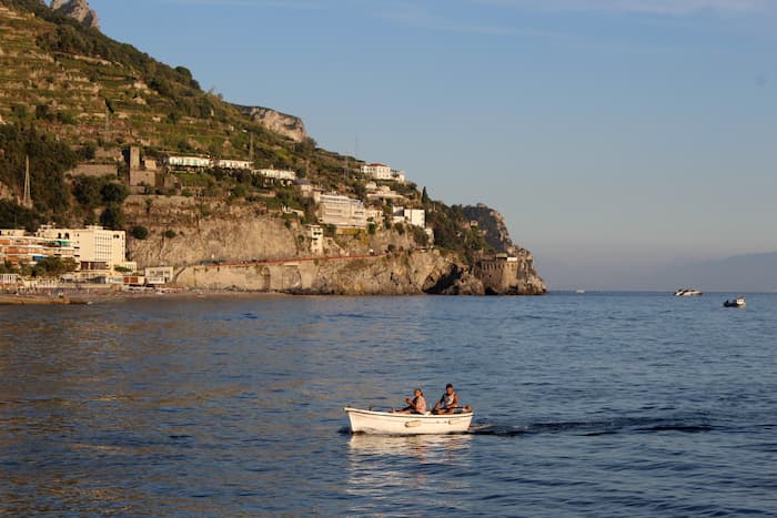 Couple in a small boat with coastline visible behind