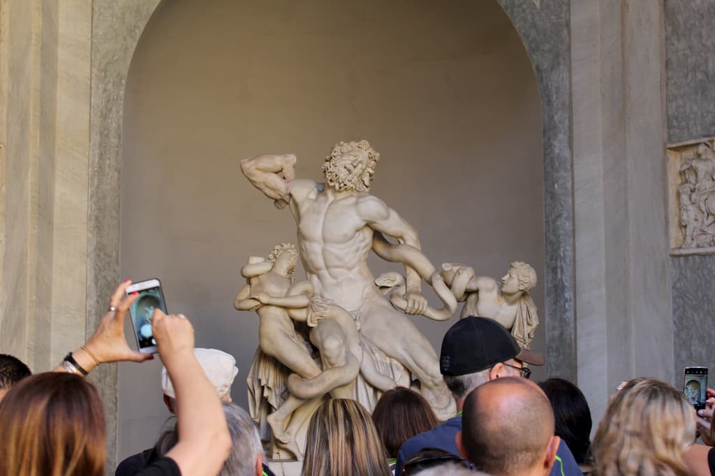 People taking pictures of a marble statue.