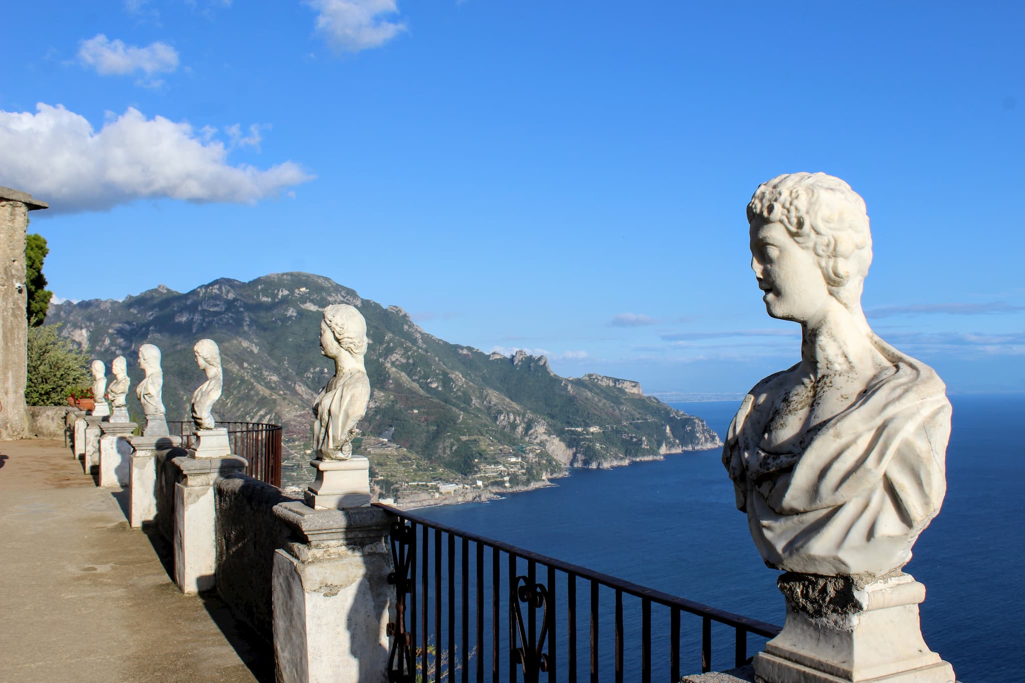 Terrace overlooking the water with stone, carved, busts along the railing