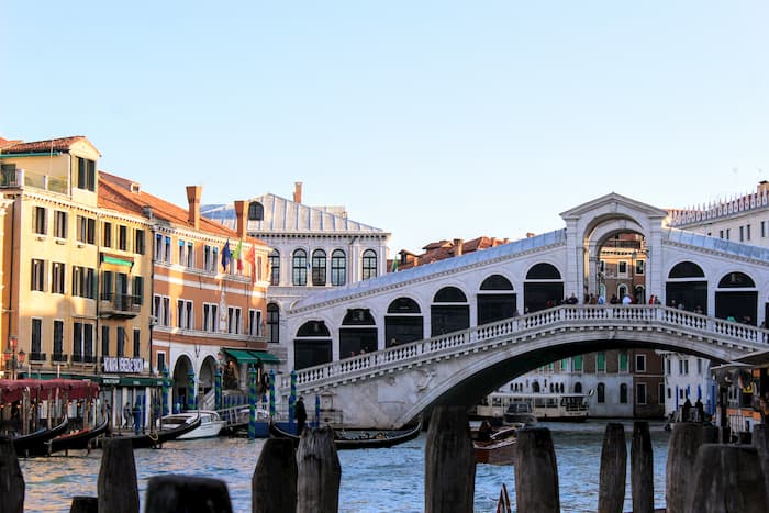 White bridge with a roofline and arches for shops.