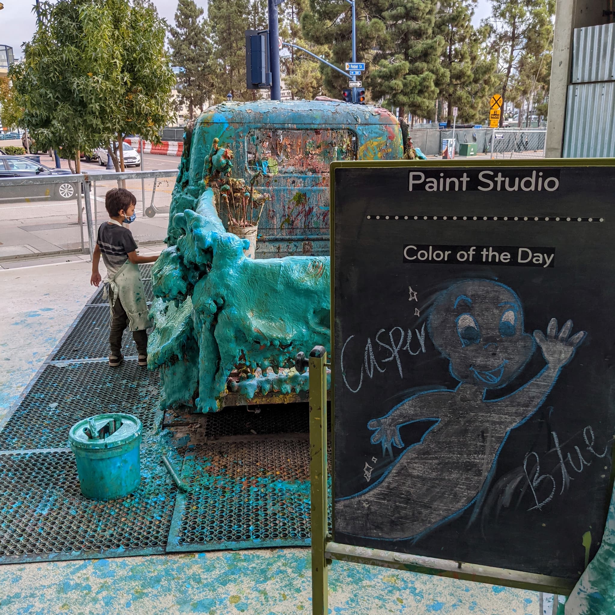 Boy putting paint on a full size truck.