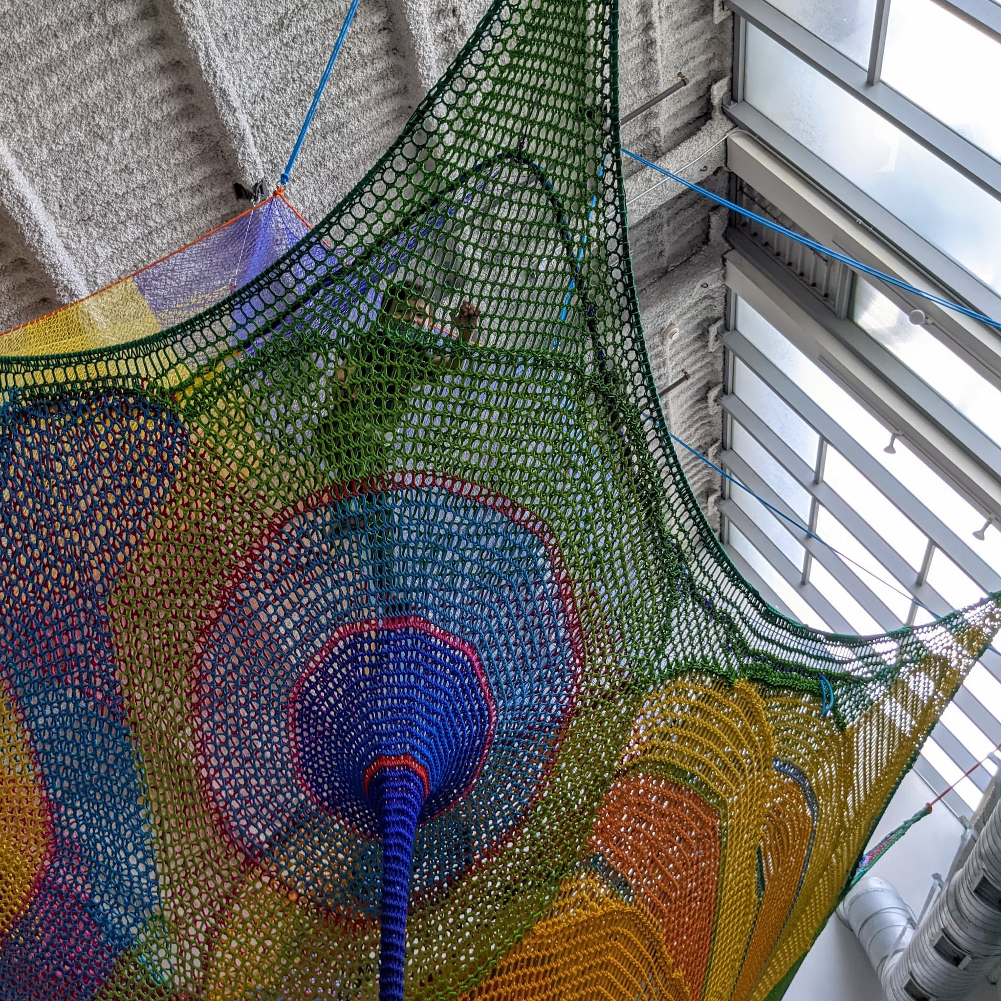 Boy climbing in colorful netting.