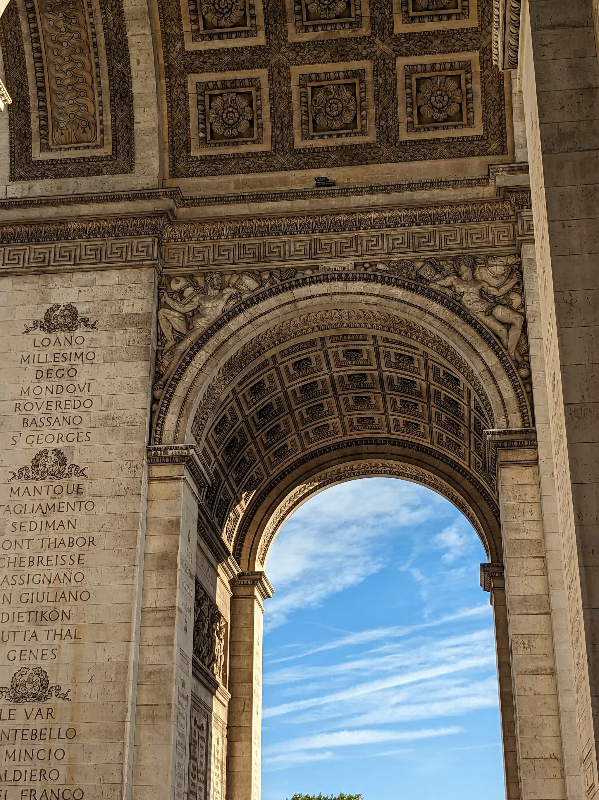 Blue sky showing through a decorative stone arch.