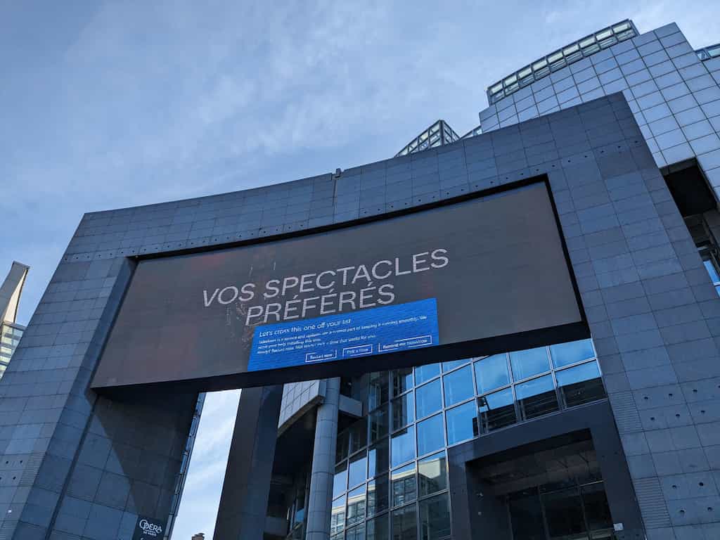 Large display on a modern building showing a blue Windows update modal over the advertizing content.
