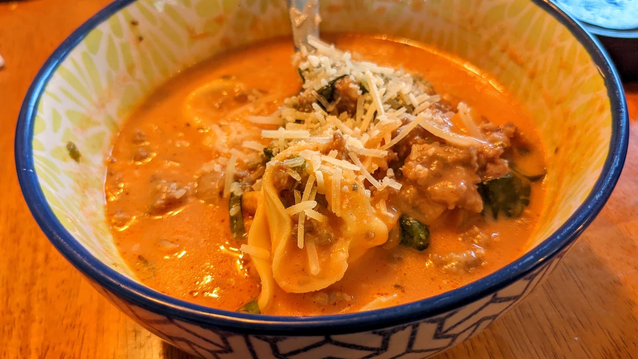 bowl of creamy red soup topped with cheese