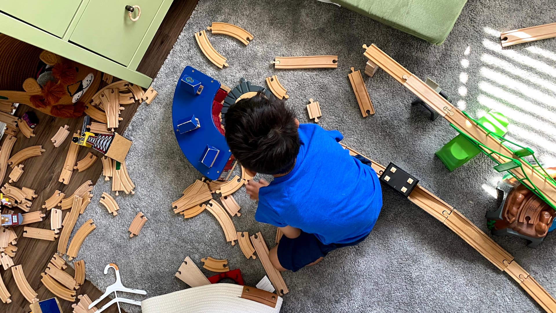 Child playing with train set.