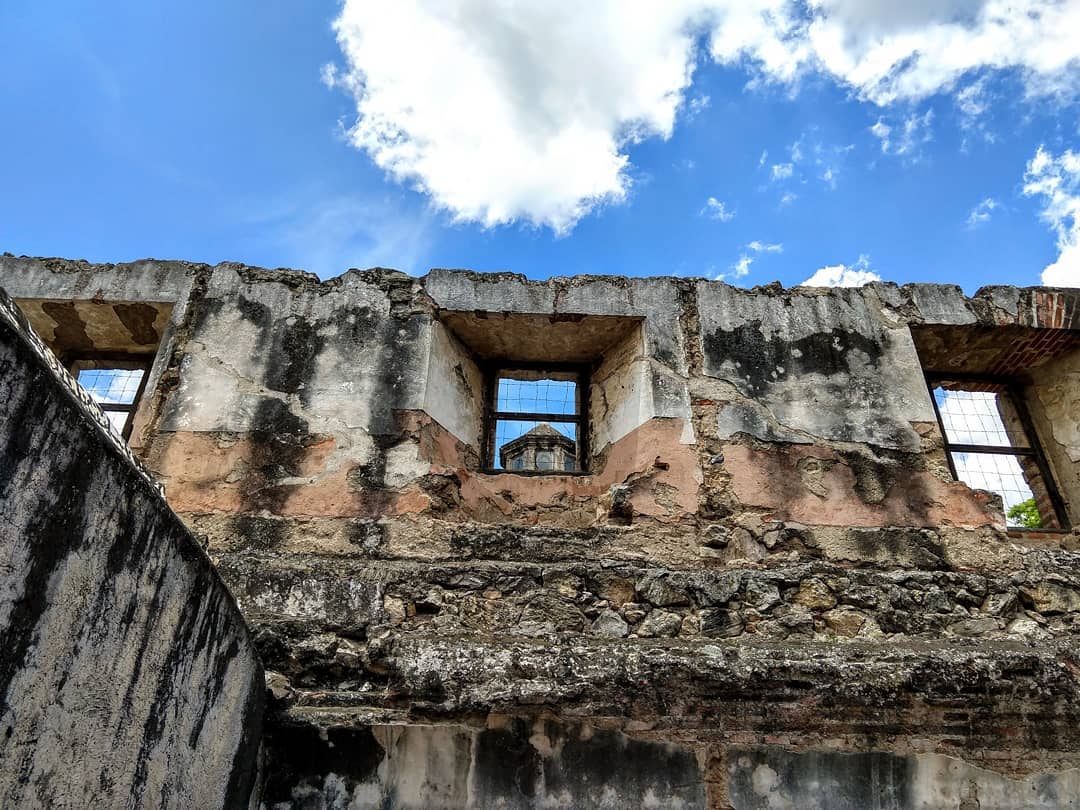 Looking through a second story window frame at the peak of a tower.