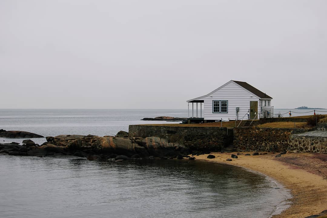 Small building on a coastline on a drab day.