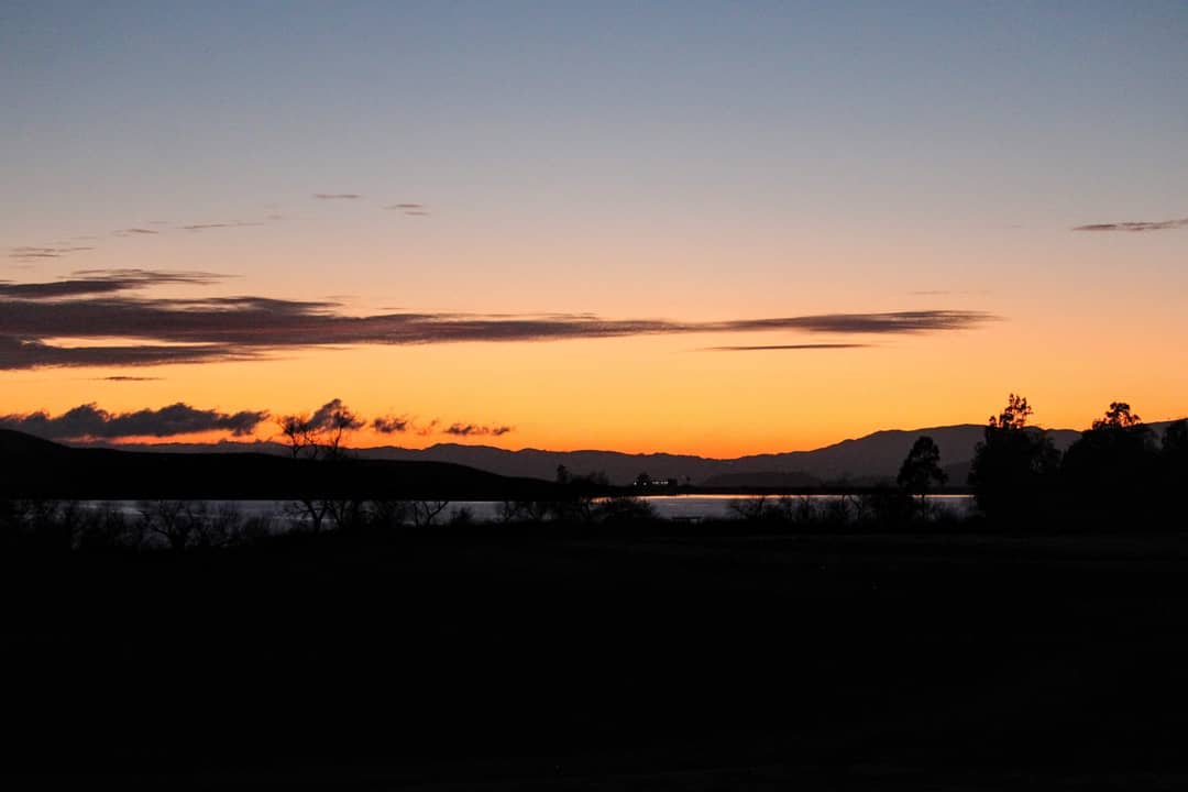 An orange sunset over a lake.