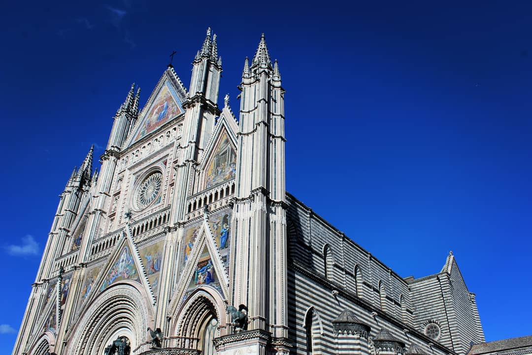 Looking up at an ornate cathedral with mosaic images on it's face