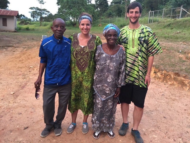 young white couple in bright green african dress next to older afican couple
