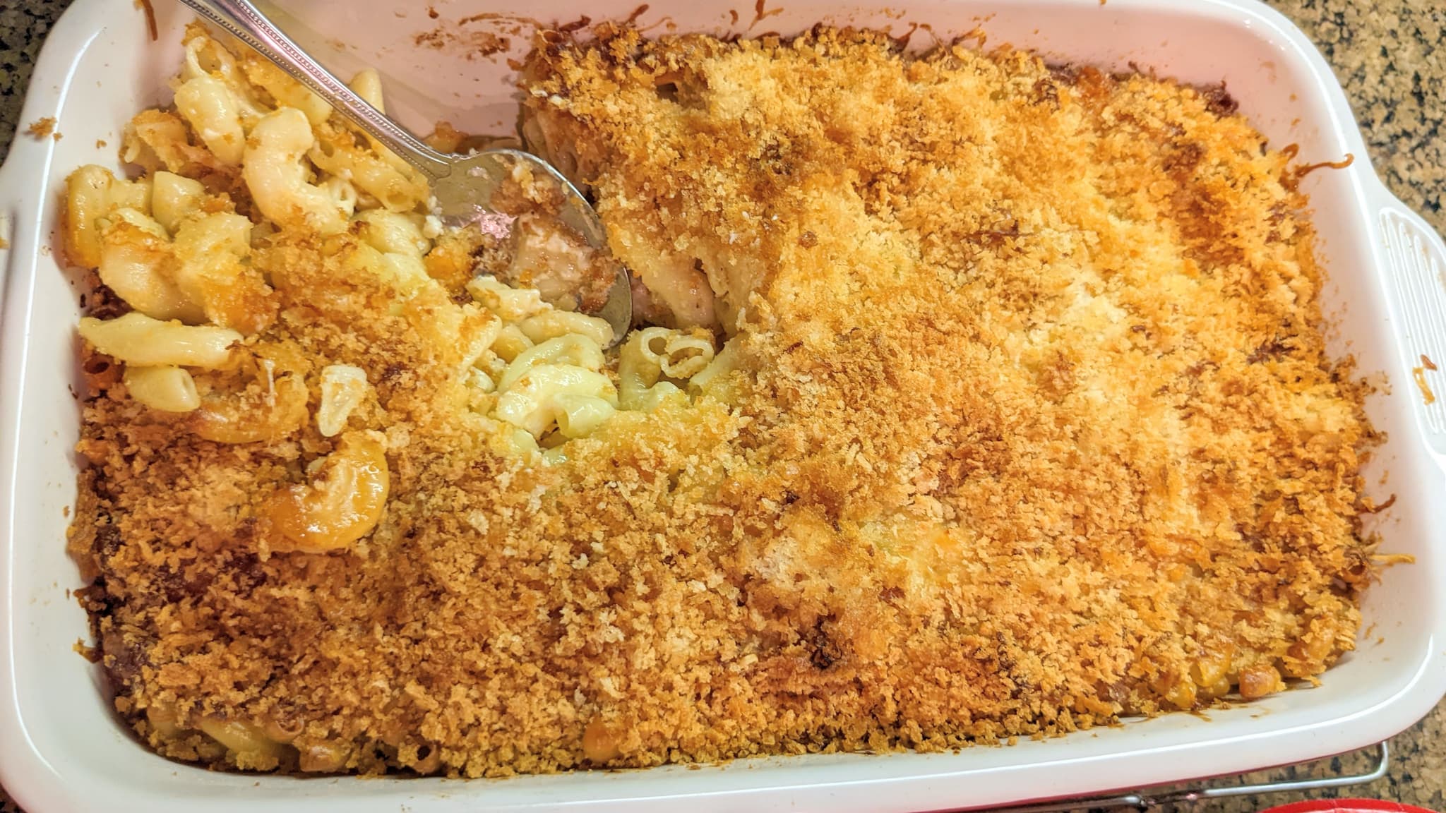 Casserole dish with baked macaroni and cheese topped with breadcrumbs.