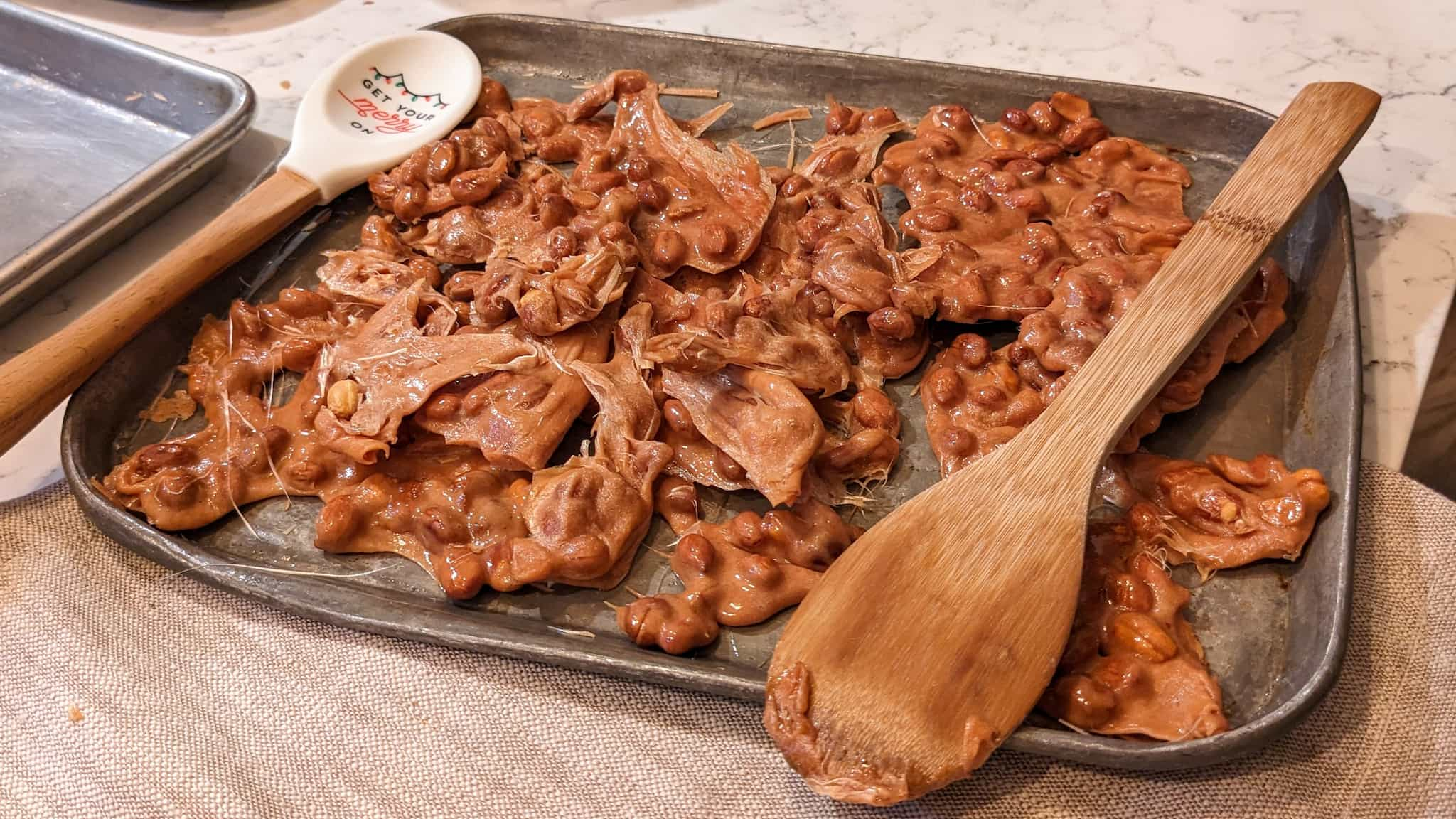 Sheet with pile of flat, fresh peanut brittle.