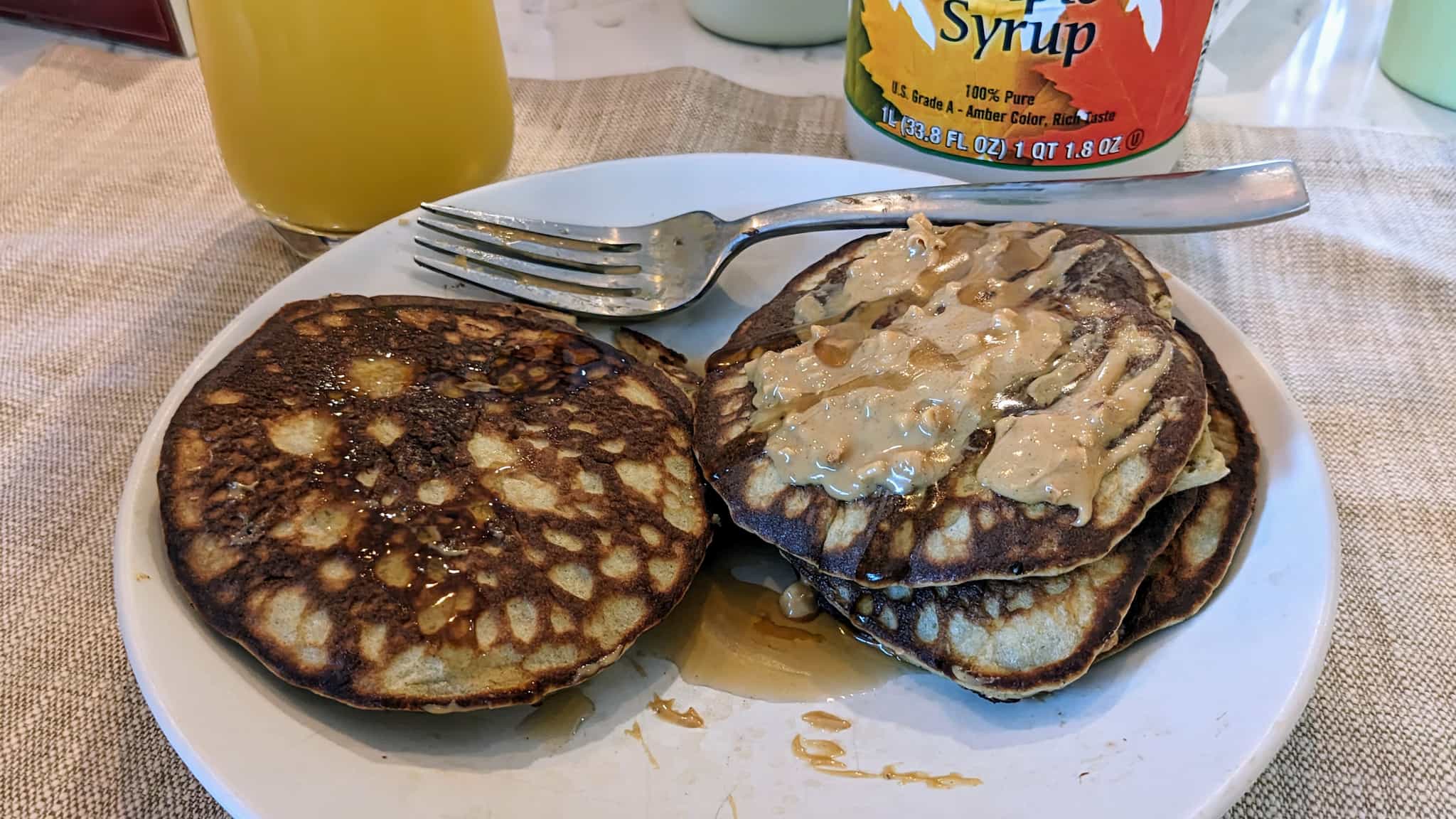 Plate of pancakes with peanut butter and syrup