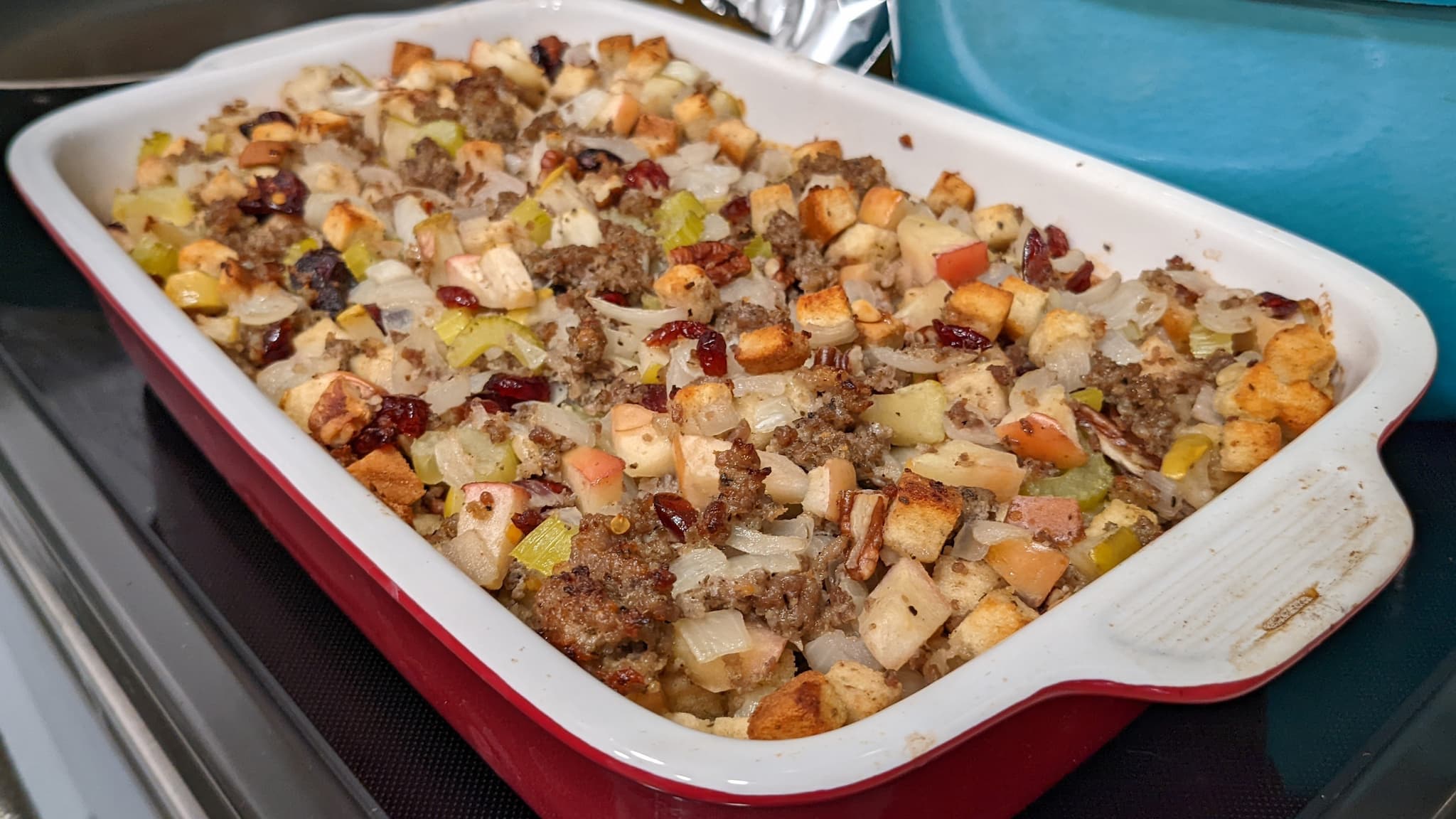 casserole dish filled with stuffing, sausage, apples and other diced ingredients.