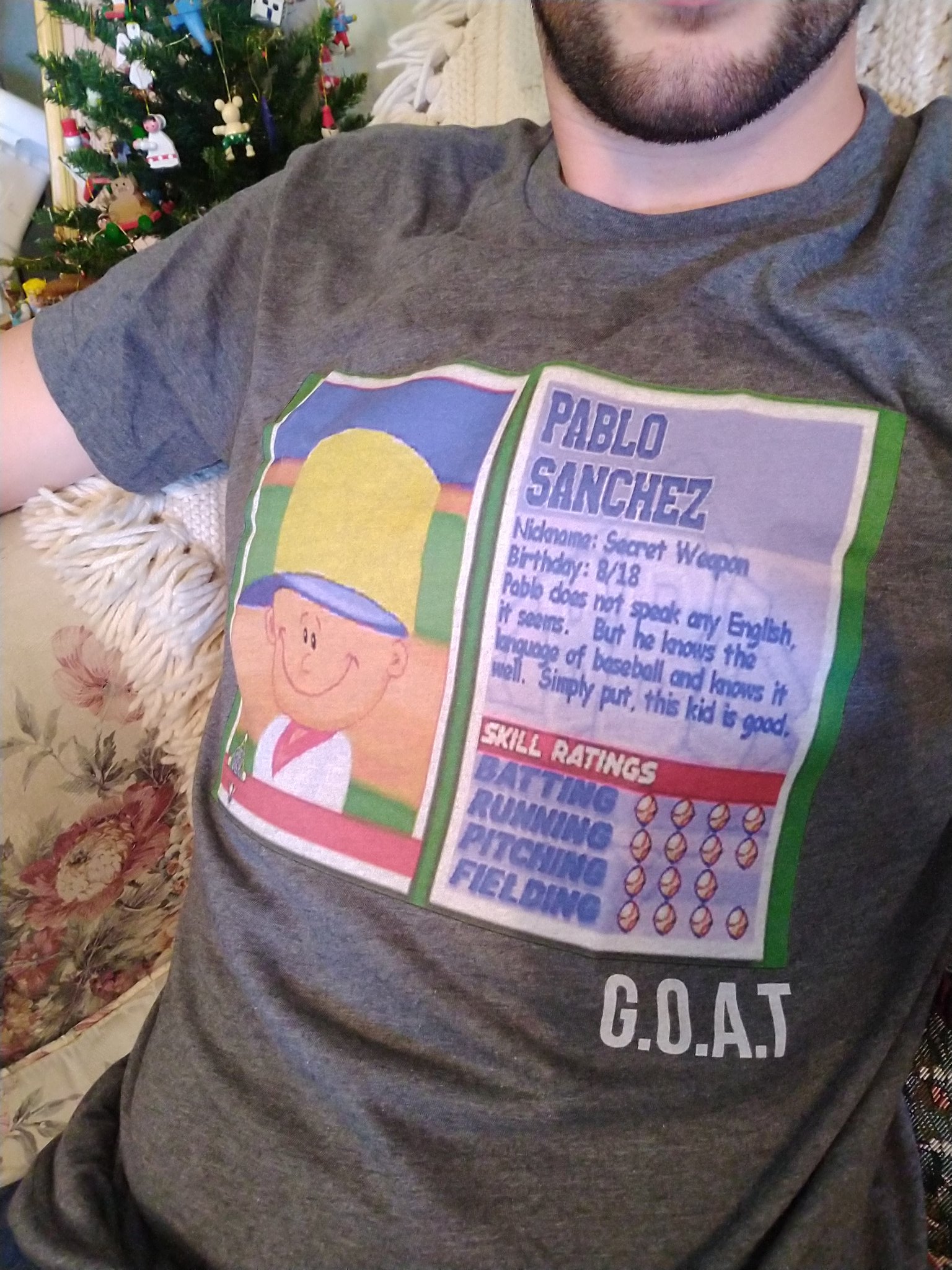 Man wearing a shirt describing the statistics of Pablo Sanchez from a video game, followed by the inscription 'G.O.A.T.'