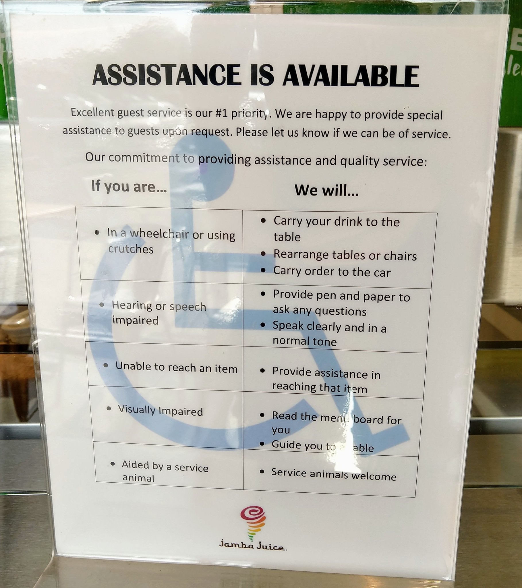 Sign on door with a handicapped symbol and the title 'Assistance is available' followed by text describing various support options.